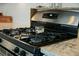 Gas stove cooktop with four burners and stainless steel range hood and granite countertops at 490 Rowley Ln, Summerville, SC 29486