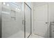 Modern tiled shower with a glass door and recessed lighting, accented by white tile and sleek fixtures at 490 Rowley Ln, Summerville, SC 29486