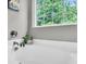 Bright bathroom showing bathtub, faucet, small decorative potted plant and window at 5228 Fallow Fawns Rd, Hollywood, SC 29449
