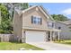 Side view of a two-story home with stone accents, a well-maintained lawn, and an attached two-car garage at 5228 Fallow Fawns Rd, Hollywood, SC 29449