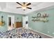 This cozy main bedroom features decorative shelves, a ceiling fan, and adjoins the main bath at 5228 Fallow Fawns Rd, Hollywood, SC 29449