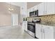 Bright kitchen with white cabinets, stainless steel appliances, and granite countertops overlooking dining area at 5376 Copley Cir, Summerville, SC 29485