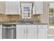 Kitchen showcasing stainless steel dishwasher, white cabinets, and granite countertops with tile backsplash at 5376 Copley Cir, Summerville, SC 29485