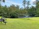 A scenic pond featuring a fountain, surrounded by green grass and benches for relaxation at 5376 Copley Cir, Summerville, SC 29485