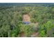 Aerial view of a blue house enveloped by lush green forest, providing a secluded living environment at 5669 Sands Rd, Hollywood, SC 29449