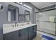 Modern bathroom with a double vanity, dual mirrors, and a glass-enclosed shower, featuring sleek black accents at 5669 Sands Rd, Hollywood, SC 29449