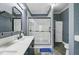 Stylish bathroom featuring double vanity sinks, a large glass shower, and attractive tile flooring with a blue rug at 5669 Sands Rd, Hollywood, SC 29449
