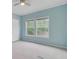 Bright bedroom with two windows allowing natural light, pale blue walls, neutral carpet, and a ceiling fan at 5669 Sands Rd, Hollywood, SC 29449