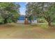 Charming home featuring a blue exterior, complemented by a well-maintained lawn and mature trees at 5669 Sands Rd, Hollywood, SC 29449
