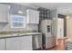 Bright kitchen with stainless steel appliances, light-colored backsplash, and a double basin sink at 5669 Sands Rd, Hollywood, SC 29449