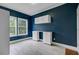 Well-lit laundry room featuring blue walls, white cabinets, tile floors, and two windows offering ample natural light at 5669 Sands Rd, Hollywood, SC 29449
