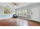 Bright living room featuring wood-look floors, a ceiling fan, and large windows at 5669 Sands Rd, Hollywood, SC 29449