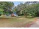 View of home, shows yard with mature tree and mulched flower beds and elevated entrance at 5669 Sands Rd, Hollywood, SC 29449