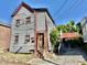 Two-story home featuring deteriorating wood siding and a small, overgrown yard needing repair at 6 Moultrie St, Charleston, SC 29403