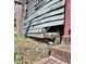 Close-up view displays damaged wood siding and exposed foundation detail needing repair at 6 Moultrie St, Charleston, SC 29403