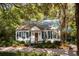 Charming cottage-style home with a lush, tree-lined yard and cozy front porch at 622 Venning St, McClellanville, SC 29458