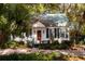 Quaint cottage home with a lush front yard featuring a cozy entry and green shutters at 622 Venning St, McClellanville, SC 29458