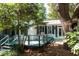 Charming home exterior featuring a backyard deck nestled among lush trees and greenery at 622 Venning St, McClellanville, SC 29458