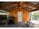 Cozy covered patio with wood paneling, ceiling fan, and outdoor grilling area at 622 Venning St, McClellanville, SC 29458