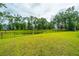 Expansive backyard featuring lush greenery, a black fence, and mature trees, perfect for recreation at 7070 Pumpkinseed Dr, Johns Island, SC 29455