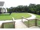 Scenic backyard view featuring a lush green lawn and a charming path leading to a tranquil lake at 7070 Pumpkinseed Dr, Johns Island, SC 29455