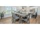 Dining area with a gray table, gray upholstered chairs, a view of the kitchen, and backyard views at 7070 Pumpkinseed Dr, Johns Island, SC 29455