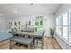 Dining area with a gray table, gray upholstered chairs and bench, and a view of the backyard at 7070 Pumpkinseed Dr, Johns Island, SC 29455