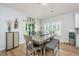 Dining area with a gray table, gray upholstered chairs and bench, and a view of the backyard at 7070 Pumpkinseed Dr, Johns Island, SC 29455