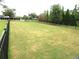 A sprawling green fenced dog park with shade trees, providing a safe and spacious area at 7070 Pumpkinseed Dr, Johns Island, SC 29455