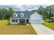 Inviting two-story home with charming front porch, manicured lawn, and attached garage at 7070 Pumpkinseed Dr, Johns Island, SC 29455