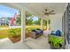 Inviting covered porch with comfortable wicker seating, white columns, and ceiling fan at 7070 Pumpkinseed Dr, Johns Island, SC 29455