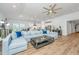 Open concept living room, kitchen, and dining room area with hardwood floors and gray sofa at 7070 Pumpkinseed Dr, Johns Island, SC 29455