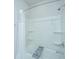 Bright bathtub and shower combination with white shower curtain and built-in shelves for storage at 7070 Pumpkinseed Dr, Johns Island, SC 29455