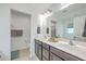 Bright bathroom featuring a double vanity with dark cabinetry and a large mirror at 7401 Purser Ln, Hanahan, SC 29410