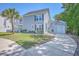 Charming two-story home with light blue siding, a garage, and a lush green lawn and palm tree at 7401 Purser Ln, Hanahan, SC 29410