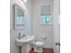Stylish half bathroom with pedestal sink, modern fixtures, and a window for natural light at 7401 Purser Ln, Hanahan, SC 29410