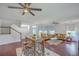 Open-concept living room featuring hardwood floors, comfortable seating, a breakfast bar, and staircase at 7401 Purser Ln, Hanahan, SC 29410