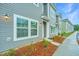 Modern townhomes with gray siding, white trim, large windows and neatly landscaped front yard at 902 Twin Rivers Drive, Wando, SC 29492