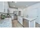 Modern kitchen features granite countertops, stainless appliances, and white cabinets at 902 Twin Rivers Drive, Wando, SC 29492