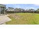 Spacious fenced backyard with lush green grass, patio, and view of surrounding homes at 9706 Fanning Basket Ln, Ladson, SC 29456