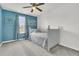 Cozy bedroom with neutral carpet, blue accent wall, ceiling fan, and a white day bed near a window at 9706 Fanning Basket Ln, Ladson, SC 29456