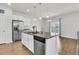 Kitchen island with granite countertop, stainless steel dishwasher, sink, and stylish pendant lighting overlooking dining area at 9706 Fanning Basket Ln, Ladson, SC 29456