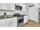 Close-up of a kitchen with stainless steel oven and microwave, granite countertops, and white cabinets for a contemporary feel at 9706 Fanning Basket Ln, Ladson, SC 29456