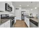 Well-lit kitchen featuring stainless steel appliances, granite countertops, and white cabinetry for a sleek and modern design at 9706 Fanning Basket Ln, Ladson, SC 29456