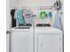 Functional laundry room features a washer, dryer, storage shelf, ironing board and assorted soaps and cleaning supplies at 9706 Fanning Basket Ln, Ladson, SC 29456