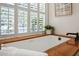 Soaking tub surrounded by a wooden trim, bright natural light and plantation shutters at 1 Marlow Dr, Charleston, SC 29403