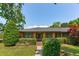 Charming one-story brick home featuring a lush front yard with manicured landscaping at 1 Marlow Dr, Charleston, SC 29403