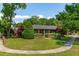 Inviting single-story home featuring manicured landscaping and mature trees at 1 Marlow Dr, Charleston, SC 29403