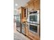 A kitchen featuring stainless steel fridge, wine cooler, double ovens, and wooden cabinets at 1 Marlow Dr, Charleston, SC 29403