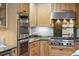 A well-equipped kitchen with wooden cabinets, stainless steel ovens, and marble countertops at 1 Marlow Dr, Charleston, SC 29403